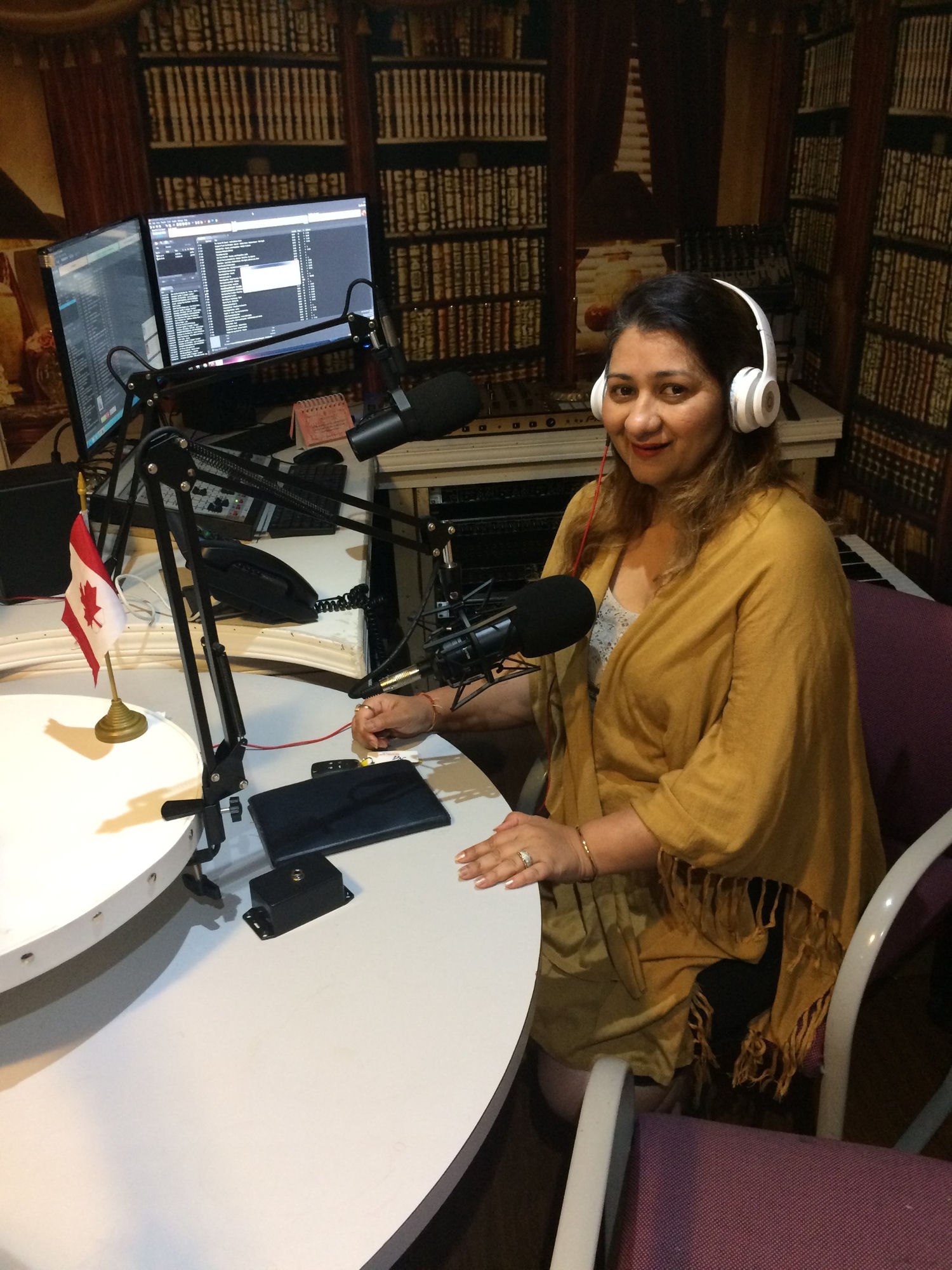 Dr. Nidhi Bhan in a professional radio studio setting — Hypnotherapist, Life Coach and Vedic Astrologer in Toronto